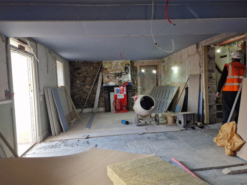 Renovatons with walls being plastered and a concrete mixture